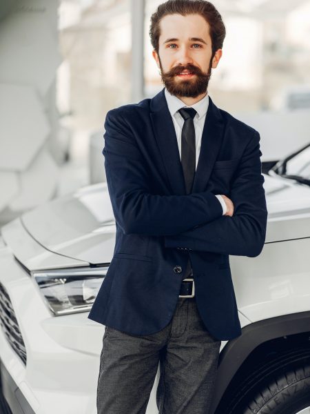 Handsome and elegant man in a car salon